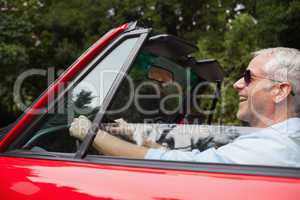Smiling handsome man driving red convertible