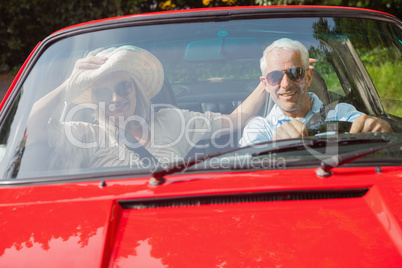 Cheerful mature couple in red cabriolet