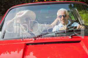 Cheerful mature couple in red cabriolet