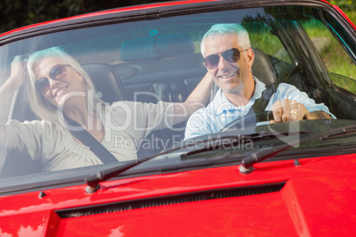 Happy mature couple in red cabriolet