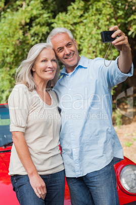 Smiling mature couple taking pictures of themselves