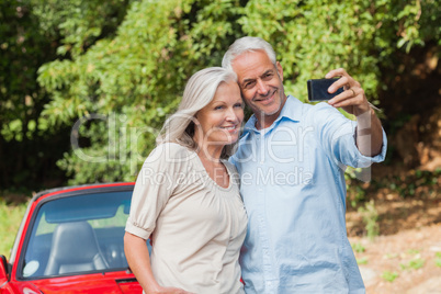 Cheerful mature couple taking pictures of themselves