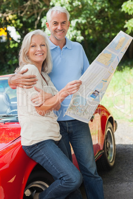 Happy mature couple reading map together