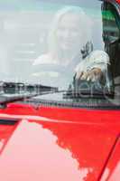 Smiling mature woman driving red cabriolet