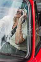 Smiling mature woman on the phone driving red cabriolet