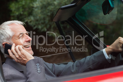 Happy businessman on the phone driving