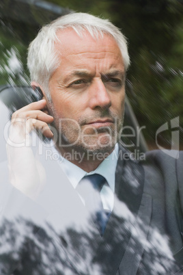 Serious businessman on the phone driving