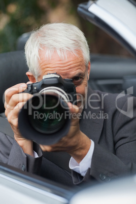 Mature paparazzi taking picture with professional camera