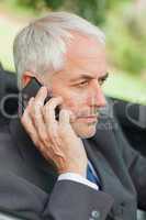 Serious businessman on the phone driving cabriolet