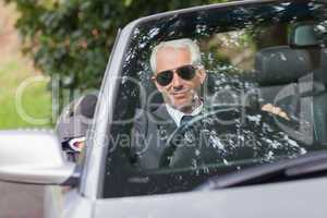 Cheerful mature businessman driving classy cabriolet