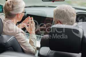 Business people working together on laptop in cabriolet