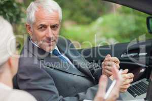 Partners working together on laptop in classy convertible