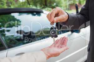 Close up on business man giving his keys to his partner