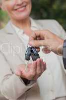 Close up on smiling businesswoman being given keys