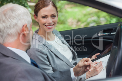 Smiling partners working together in classy car