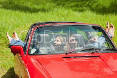 Smiling young couple relaxing in classy cabriolet