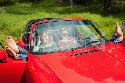 Cheerful young couple relaxing in classy cabriolet