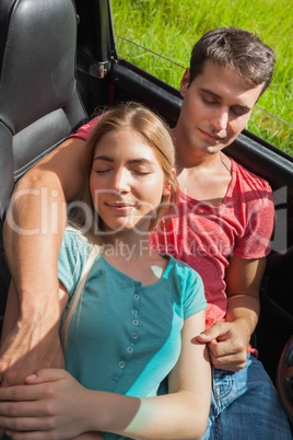 Overhead of cute couple relaxing in their cabriolet
