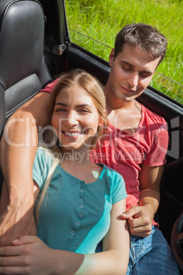 Overhead of pretty couple relaxing in their cabriolet