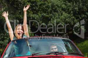 Happy couple having fun in their red cabriolet