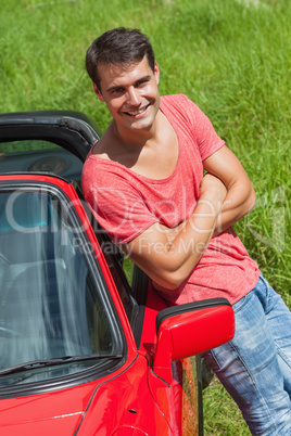 Handsome man leaning against his cabriolet