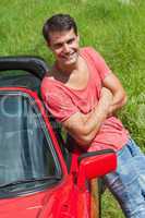 Handsome man leaning against his cabriolet