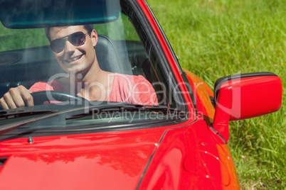 Smiling handsome man driving his cabriolet