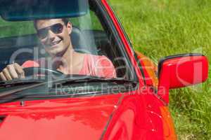 Smiling handsome man driving his cabriolet