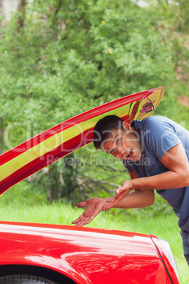 Lost young man checking his car engine after breaking down