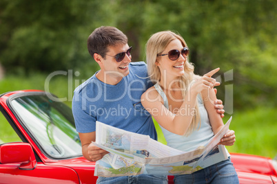 Cheerful young couple reading map
