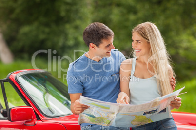 Happy young couple reading map