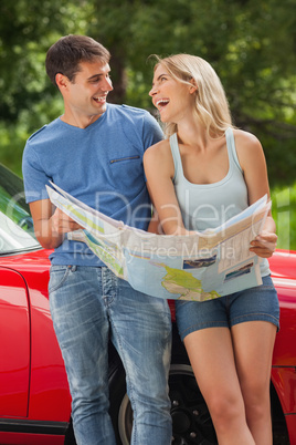 Smiling young couple reading map