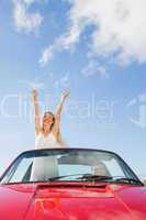 Cheerful woman standing in cabriolet while her boyfriend driving