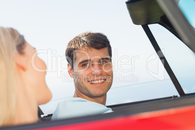 Smiling man looking at his pretty girlfriend while driving