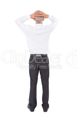 Businessman standing back to camera with hands on head