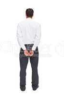 Rear view of young businessman wearing handcuffs