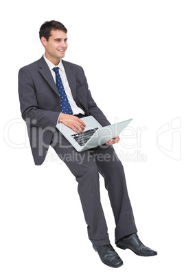 Smiling businessman sitting using a laptop