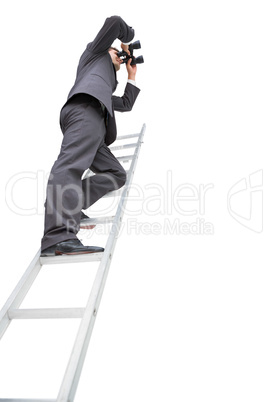 Low angle view of businessman standing on ladder using binocular