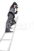 Low angle view of businessman standing on ladder using binocular