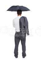 Businessman standing back to camera holding umbrella and jacket