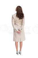 Rear view of businesswoman crossing hands behind back