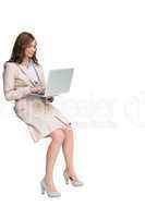 Smiling businesswoman sitting and using laptop