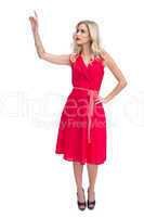 Cheerful woman in red dress waving