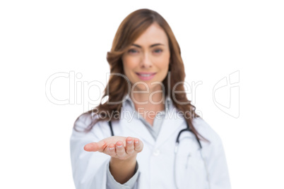 Smiling doctor showing something in her hand