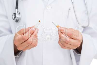 Doctor breaking cigarette