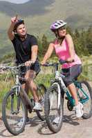 Happy couple on a bike ride with man pointing