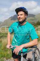 Fit man leaning on his mountain bike