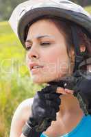 Athletic woman adjusting her bike helmet
