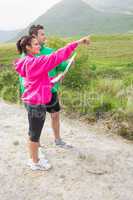 Couple holding a map and pointing ahead