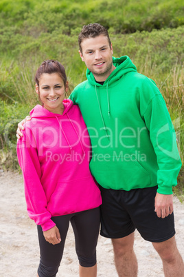 Athletic couple looking at camera and embracing